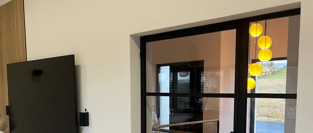 Lofttür aus Stahl mit feststehendem Seitenteil, beide Felder im selben Rahmen und mit durchlaufender Sprossenteilung