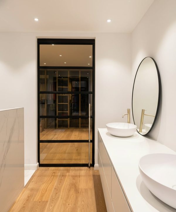 Stahl-Loft-Schiebetür zwischen Badezimmer und Ankleideraum in modernem Interieur
