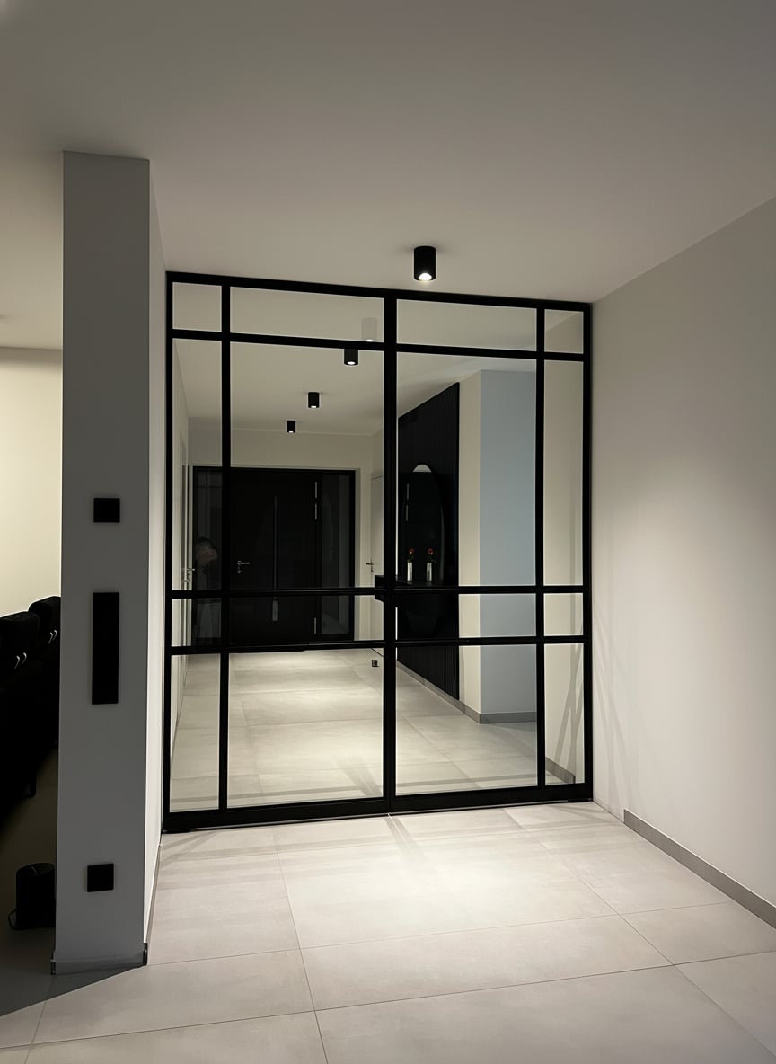 Gesamtansicht der Pivottür-Anlage mit TV-Wand im Vordergrund