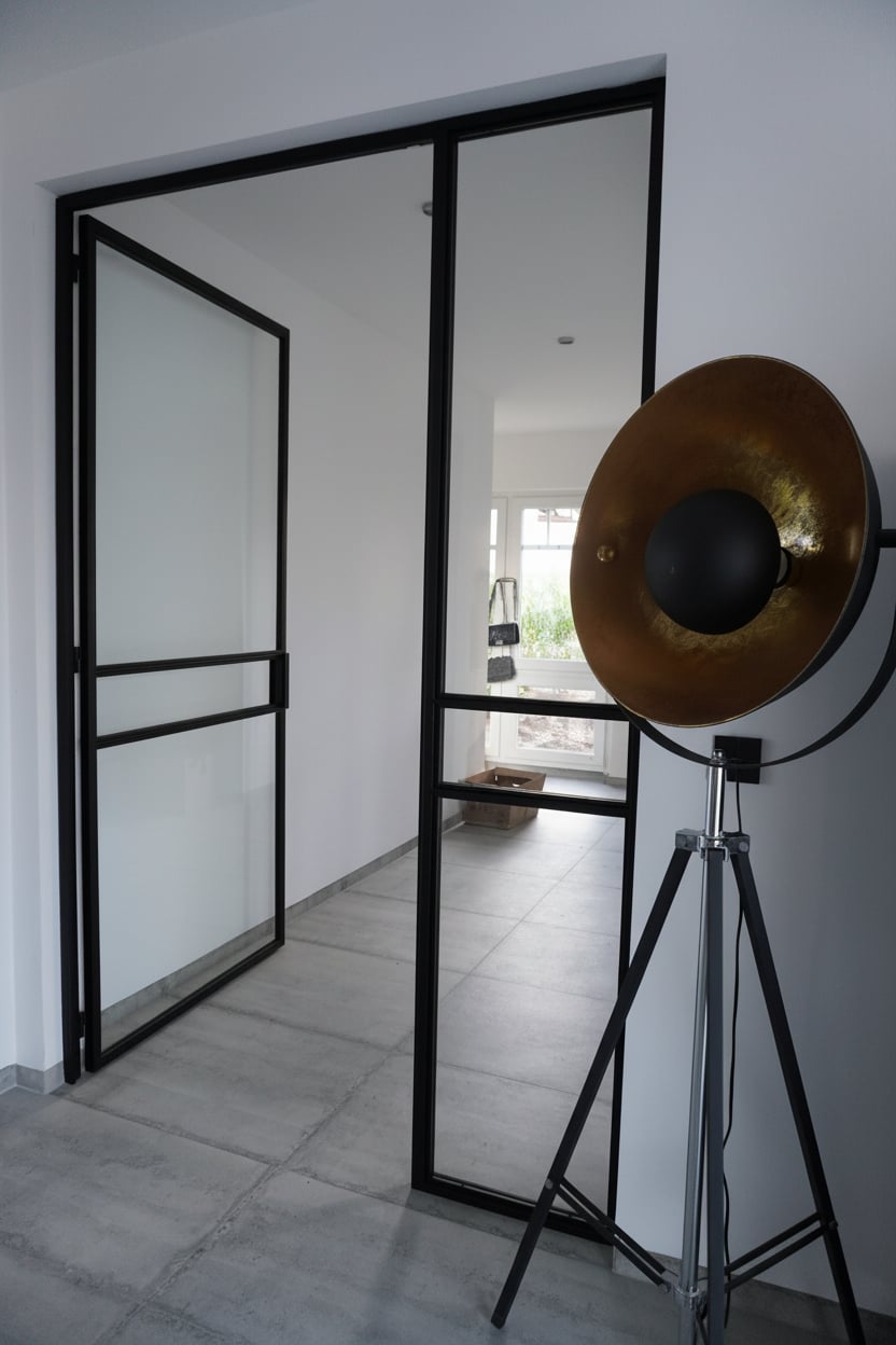 Raumhohe Festverglasung an Sichtbeton-Wand im Loft