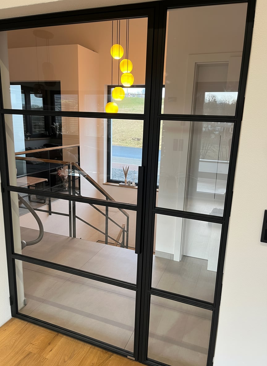 Detailansicht der Drehtür mit Seitenteil und Treppe im Hintergrund